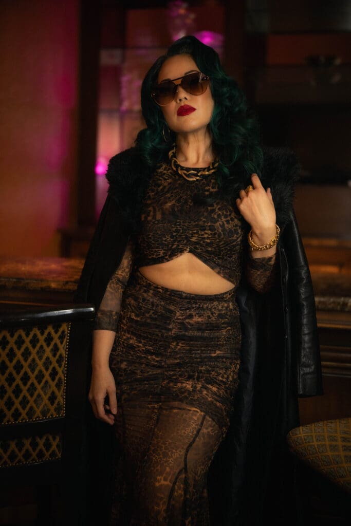 Woman modeling leather coat and cheetah print dress 